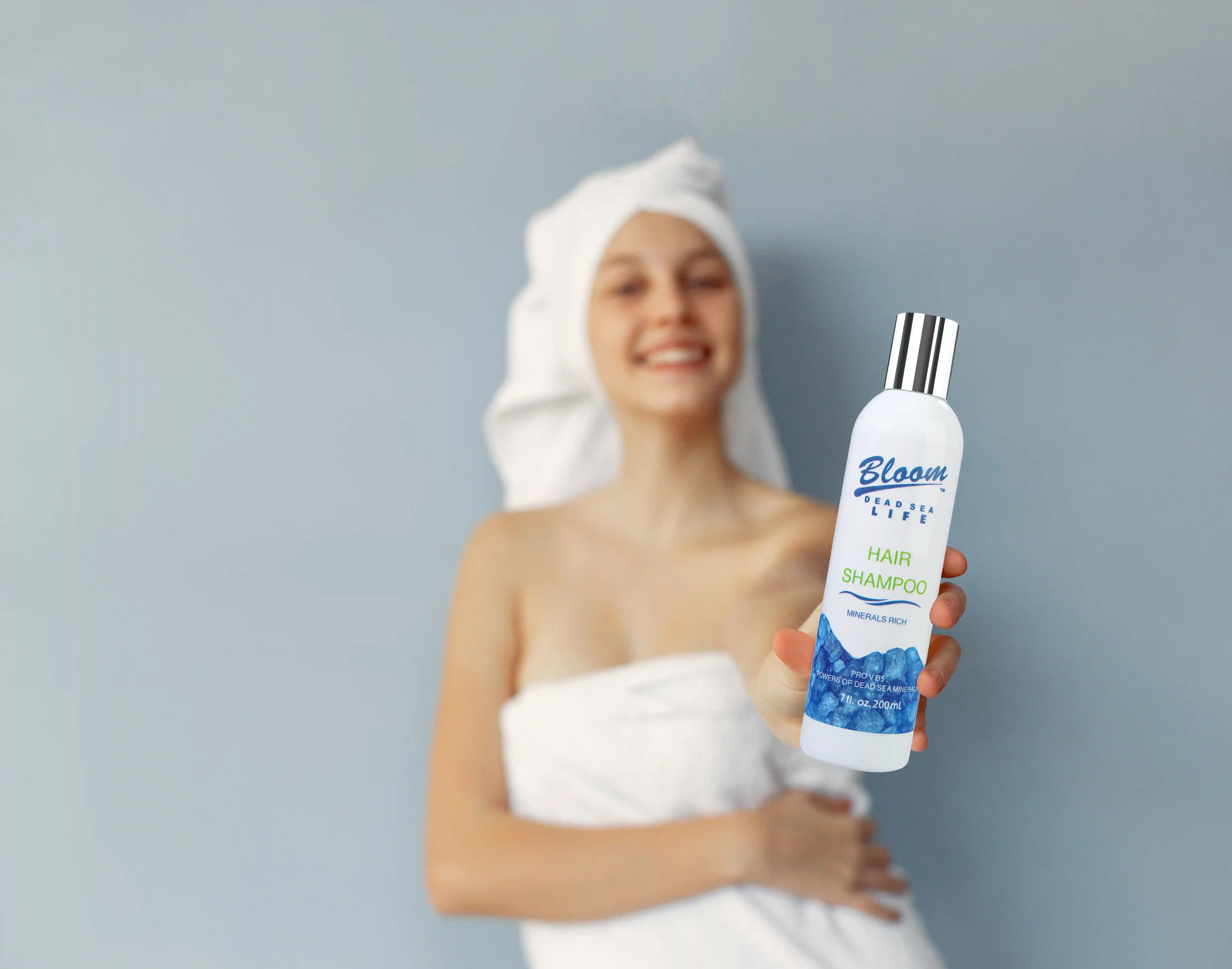 Woman ready for bath using Bloom Dead Sea shampoo while promoting Bloom Dead Sea Life affiliate program for skincare commissions and discounts.