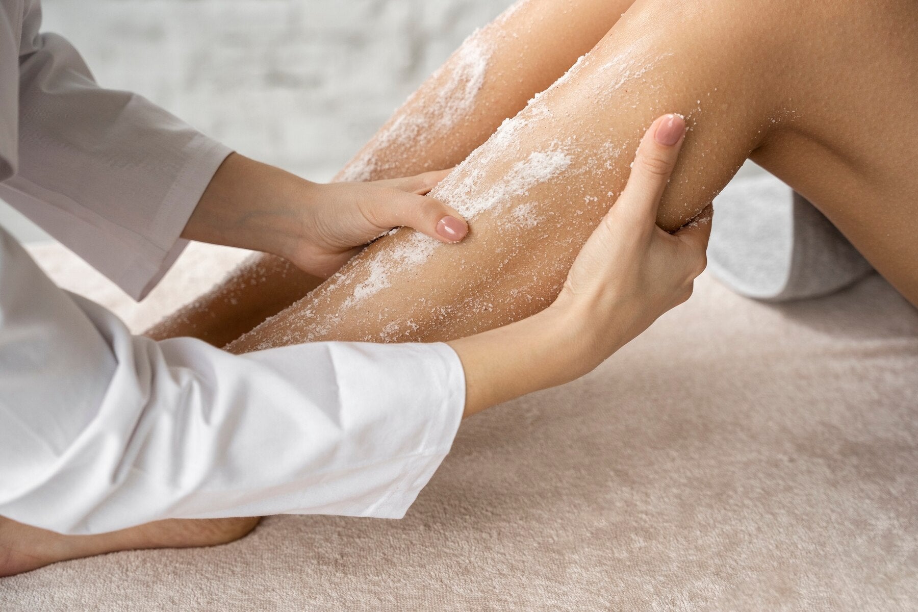A woman applying body scrub with bath salt for better skin health 